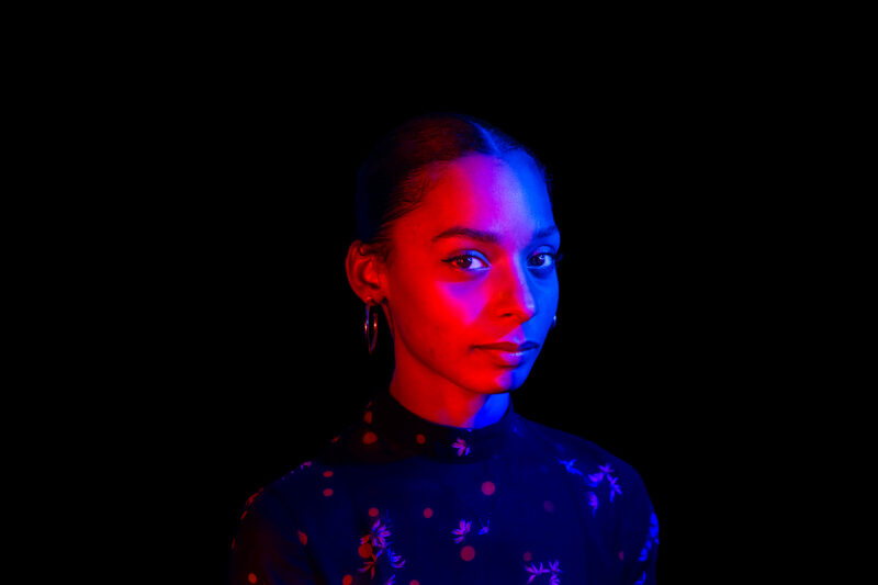 A stylized red and blue neon portrait of a woman in a qtr pose on a black background