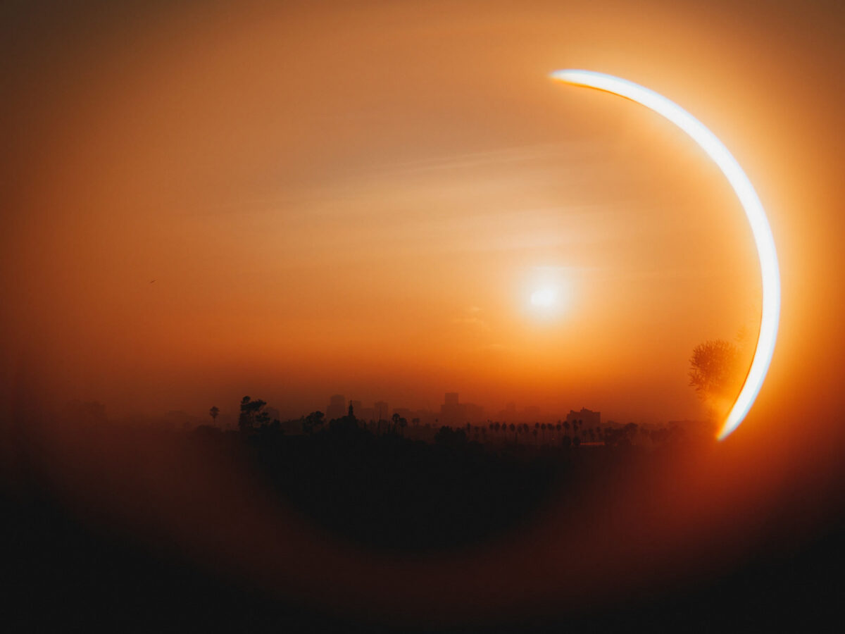 Abstract orange lens flare reflection resembling an eye over the los angles skyline