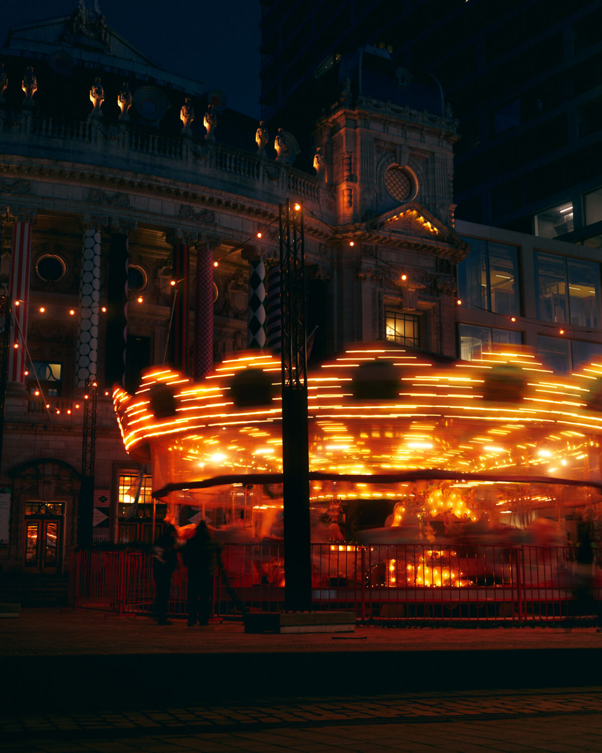 Carousel glowing at night with warm lights and motion blur
