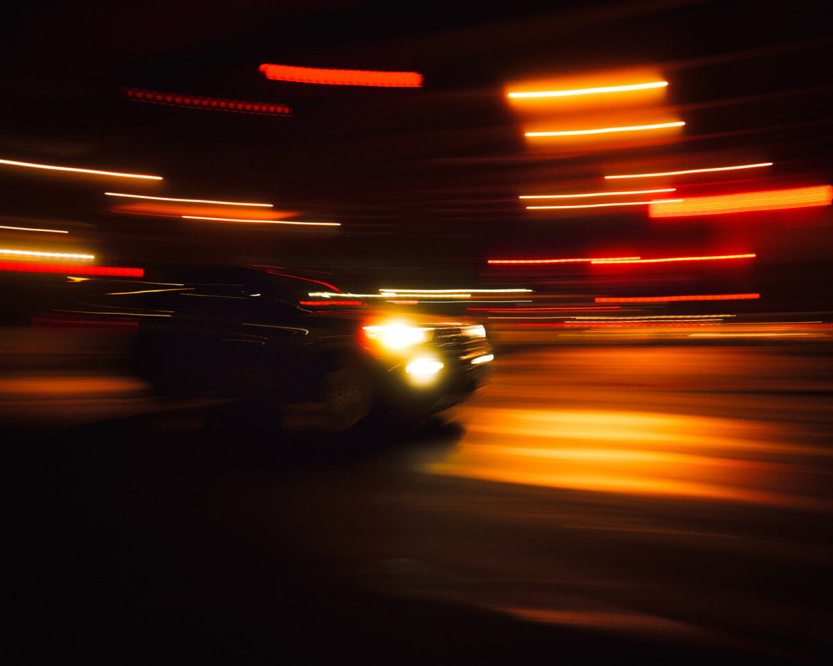 Red and orange light streaks moving through a city street at night