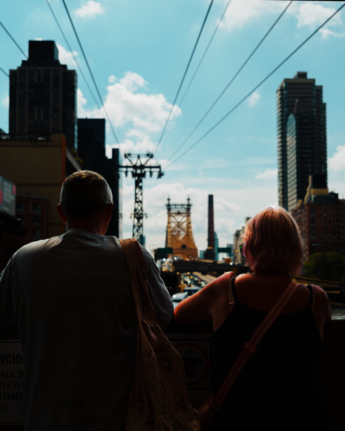 A couple looking out toward the New York City skyline from above