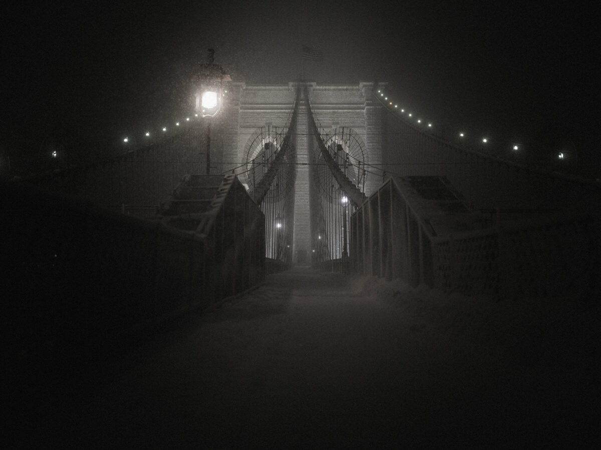 The Brooklyn Bridge engulfed in heavy snowfall during a winter storm in New York City.