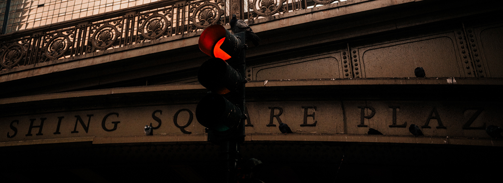 A red traffic light in front of the ornate Pershing Square Plaza viaduct near Grand Central.
